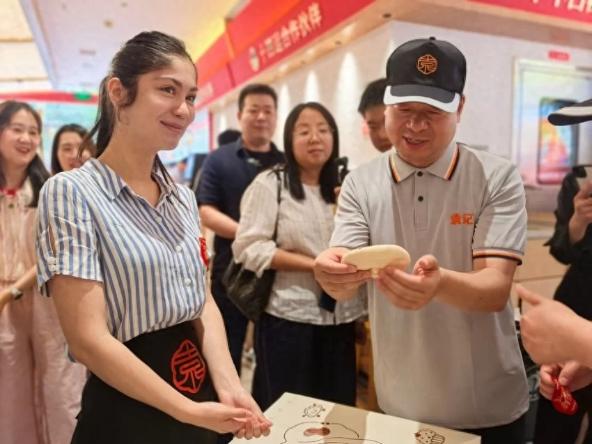 非遗肉夹馍破圈潮玩 中外青年争当“长安打馍人”